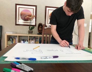 Ethan Block, 16, of Pennington, New Jersey, makes a sign with the slogan 