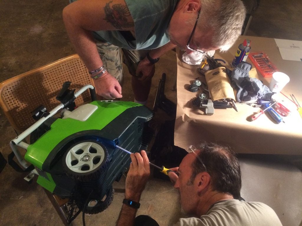 Henry Ligier and Luca Favaro work to try and fix a broken power washer. 