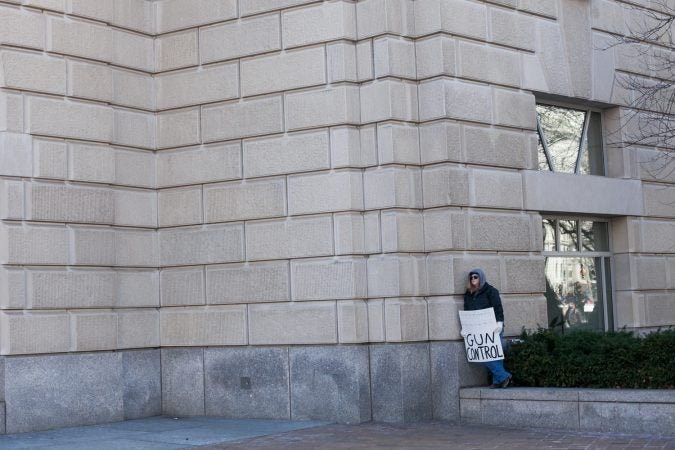A lone protestor takes a break from the large during the March for Our Lives Saturday in Washington D.C. (Brad Larrison for WHYY)