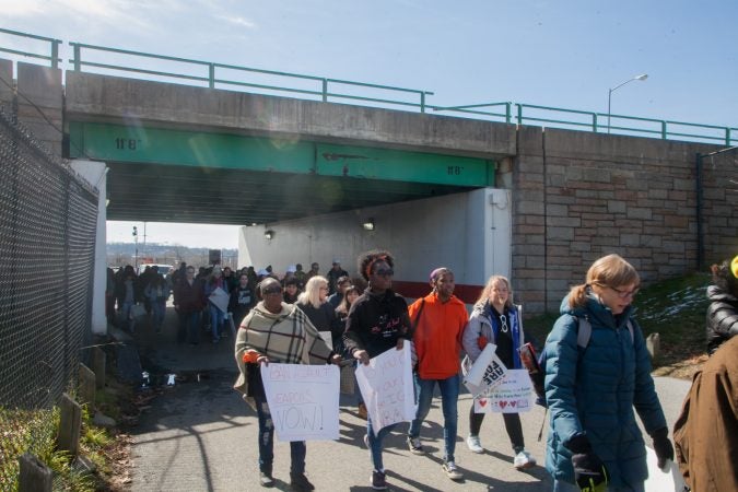 Stephanie Devaughn, (left), and her daughter Kyla make their way toward the March for Our Lives along with students, parents and teachers from Science Leadership Academy Beeber Campus. (Brad Larrison for WHYY)