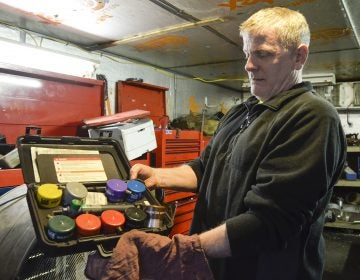 Scott Reynolds, owner of Express Transmission in Beaver County, shows an array of gas cap adapters. The adapters are used as a part of Pennsylvania's vehicle emission testing program. (Amy Sisk/StateImpact Pennsylvania)