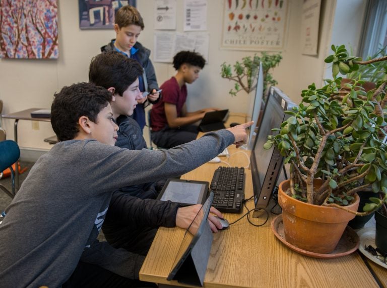 From left to right: Diego Uribe, Ben Shaman, Jake Richard, and Quinn Berger evalute Pennsylvania's new congressional district map compared to the 2011 version at the Westtown School in West Chester, Pa. (Lindsay Lazarski/WHYY)