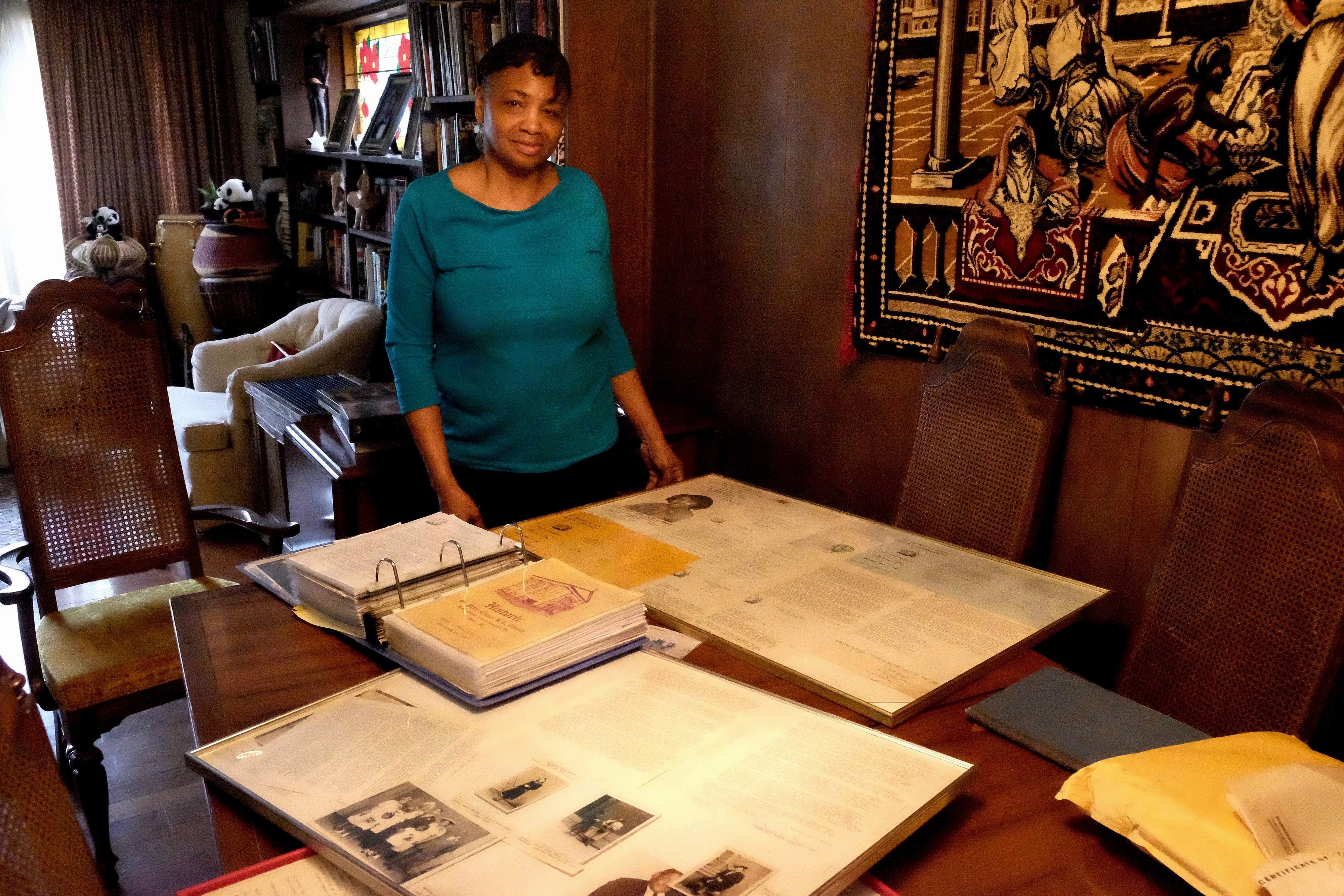 Adrienne Harris, a lifelong member of the St. Peter Claver Church and School community at home with some of her collected parish history.