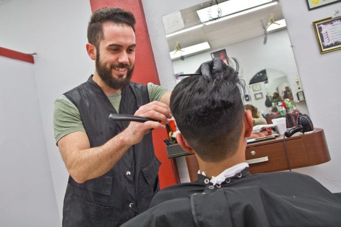 Alberto Carrasco is the owner of D'Classico Barbershop in Olney. (Kimberly Paynter/WHYY)