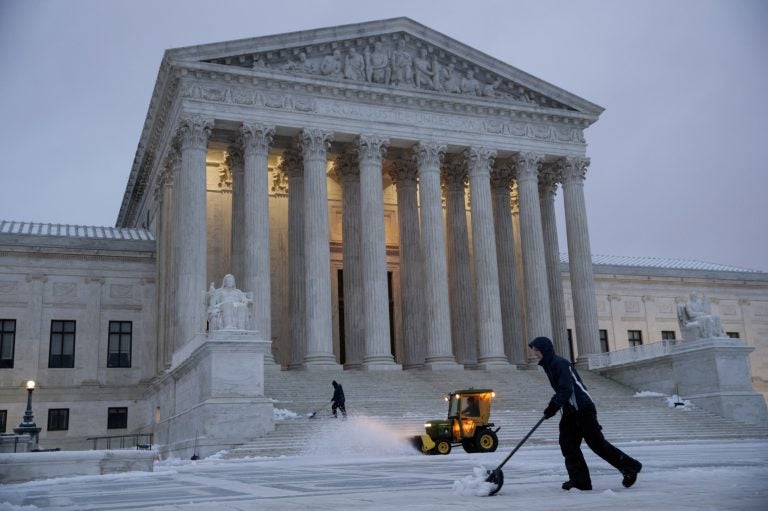 Workmen clear snow in front of the U.S. Supreme Court earlier this month.
(J. Scott Applewhite/AP)