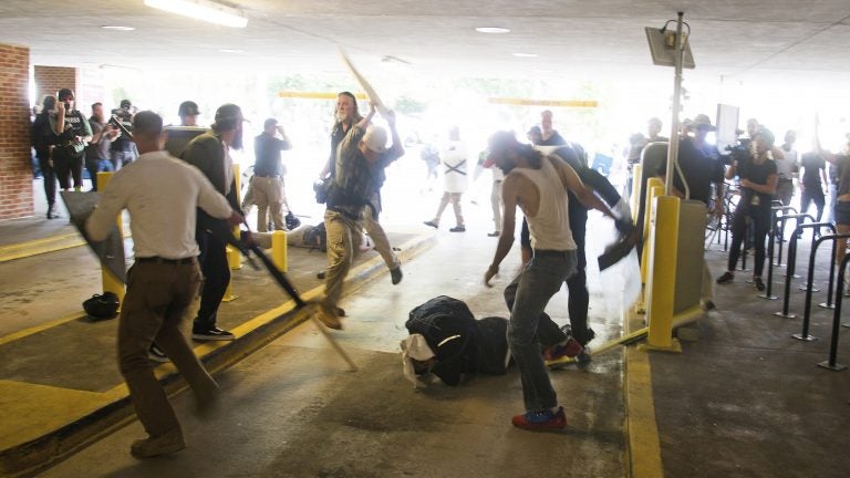 DeAndre Harris, seen balled on the ground, suffers a beating in a parking garage near the Charlottesville police station after the white nationalist rally last August. Zach D. Roberts/AP
