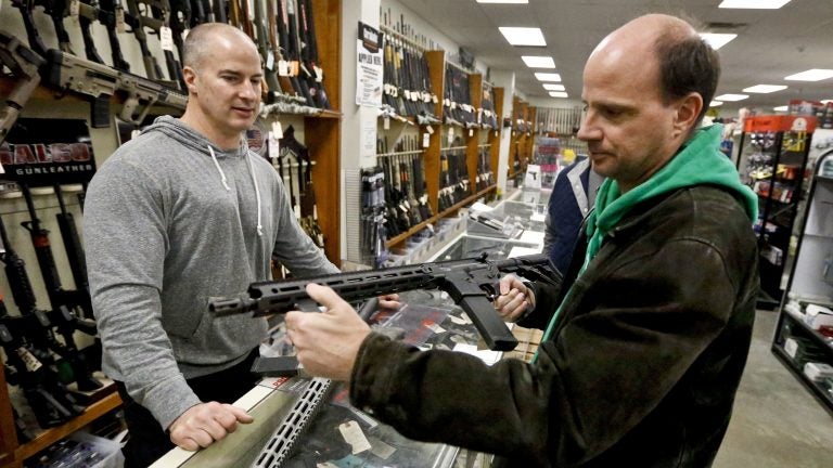 Wes Morosky, left, owner of Duke's Sport Shop helps Ron Detka as he shops for a rifle at his store in New Castle, Pa.