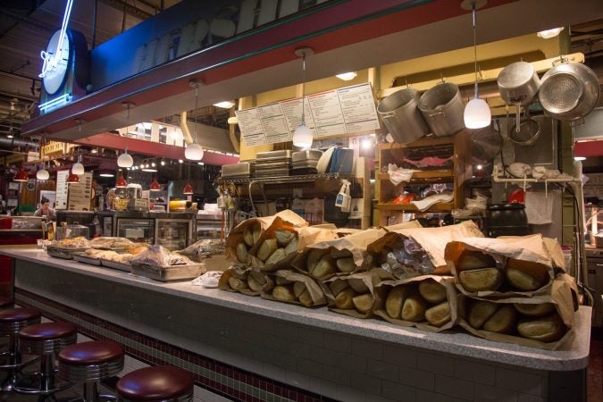 70 loaves of bread join the oven fresh meats on the counter of Hershel’s as the morning prep continues. (Emily Cohen for WHYY)