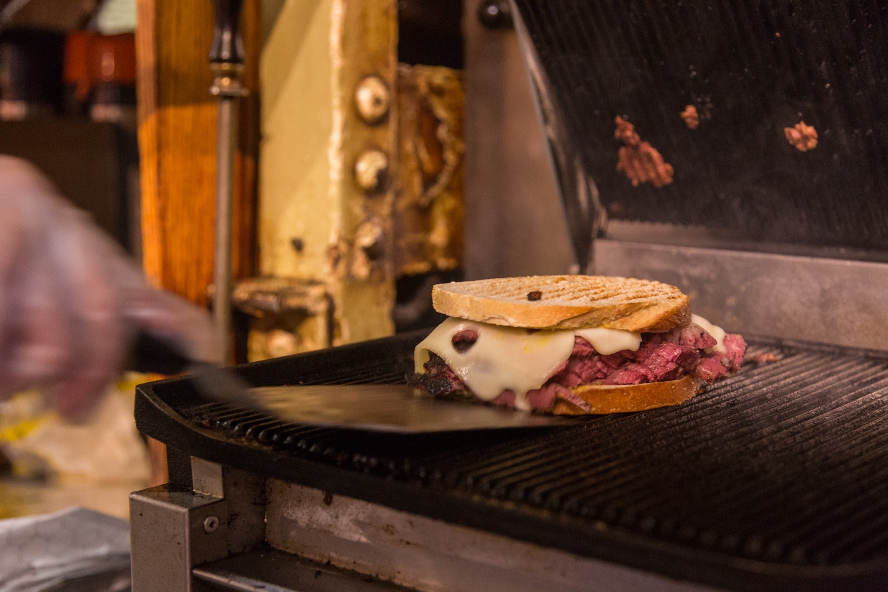 A grilled Pastrami special is taken from the grill.