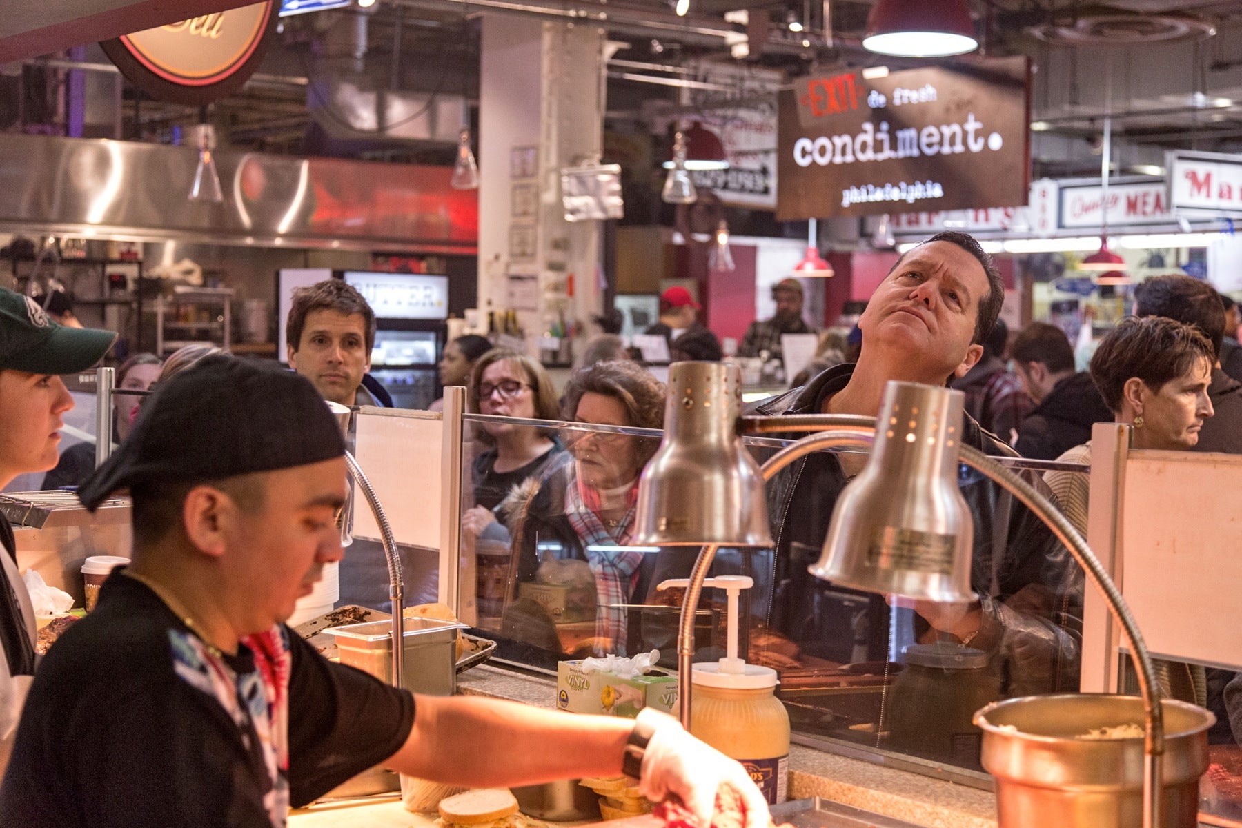 A patron looks up at the menu as he decides what he wants to order. 