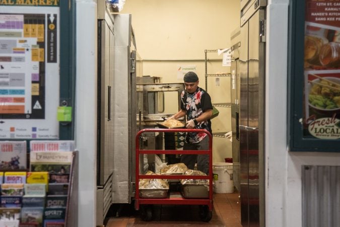 It’s 5am and Jhovani “G” Posada, 37, removes the cooked meat from their ovens to prep them for the morning rush. (Emily Cohen for WHYY)