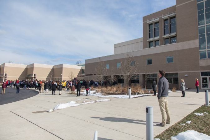 Teachers and faculty at Lower Merion High School form a perimeter around their students