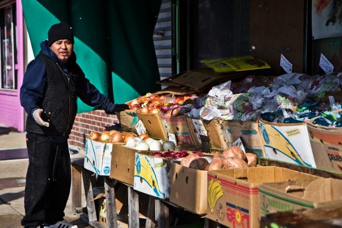 Davey Gasper socks the produce stand on 5th Street in Olney. (Kimberly Paynter/WHYY)