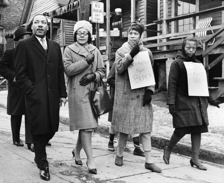 Dr. Martin Luther King, Jr., left, and his wife, Coretta Scott King, second from left, join pickets during a tour of an Atlanta slum area