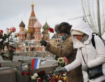 People lay flowers at the place where Russian opposition leader Boris Nemtsov was gunned down, next to the Kremlin Wall, in Moscow, Russia, Sunday, Feb. 25, 2018. Thousands of Russians took to the streets of downtown Moscow to mark three years since Nemtsov was gunned down outside the Kremlin. (AP Photo/Alexander Zemlianichenko)