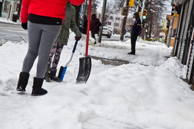 Residents clean up after the snow Thursday morning in West Philadelphia. (Kimberly Paynter/WHYY)