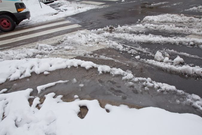 Slush mounds on roads in Philadelphia as temperatures move above freezing Thursday morning. (Kimberly Paynter/WHYY)