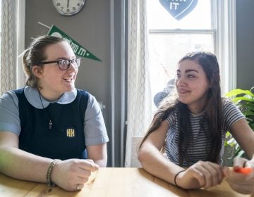 Seventeen-year-olds Maxine Van Osten, left, and Finn Kairer hang out after school in Philadelphia. Both girls have voluntarily reduced their time on their phones and social media. (Jessica Kourkounis for WHYY)