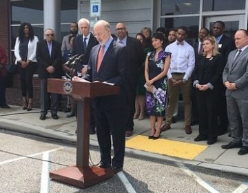 Governor Tom Wolf, Corrections Secretary John Wetzel, and a number of other advocates for new justice norms in Pennsylvania speak outside the Dauphin County Judicial Center. (Katie Meyer/WITF)