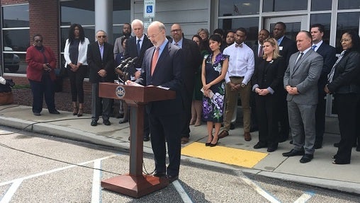 Governor Tom Wolf, Corrections Secretary John Wetzel, and a number of other advocates for new justice norms in Pennsylvania speak outside the Dauphin County Judicial Center. (Katie Meyer/WITF)