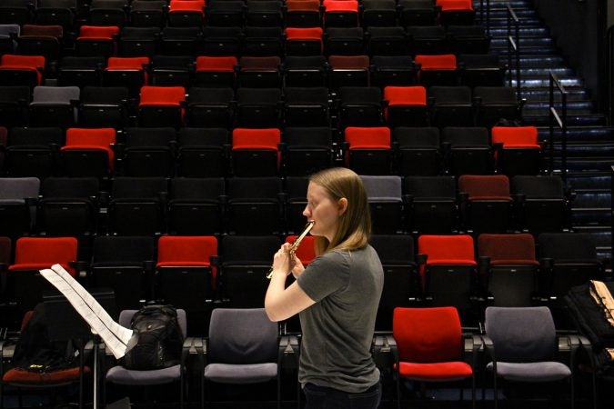 Emma Resmini plays the flute during a rehearsal on the Fringe Arts stage for Analog Arts' production of Klang by Karlheinz Stockhausen. (Emma Lee/WHYY