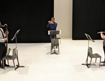 Performing Schönheit, (from left) Sean Bailey, bass clarinet, Marco Blaauw, trumpet, and Emma Resmini, flute, rehearse on the Fringe Arts stage. (Emma Lee/WHYY)