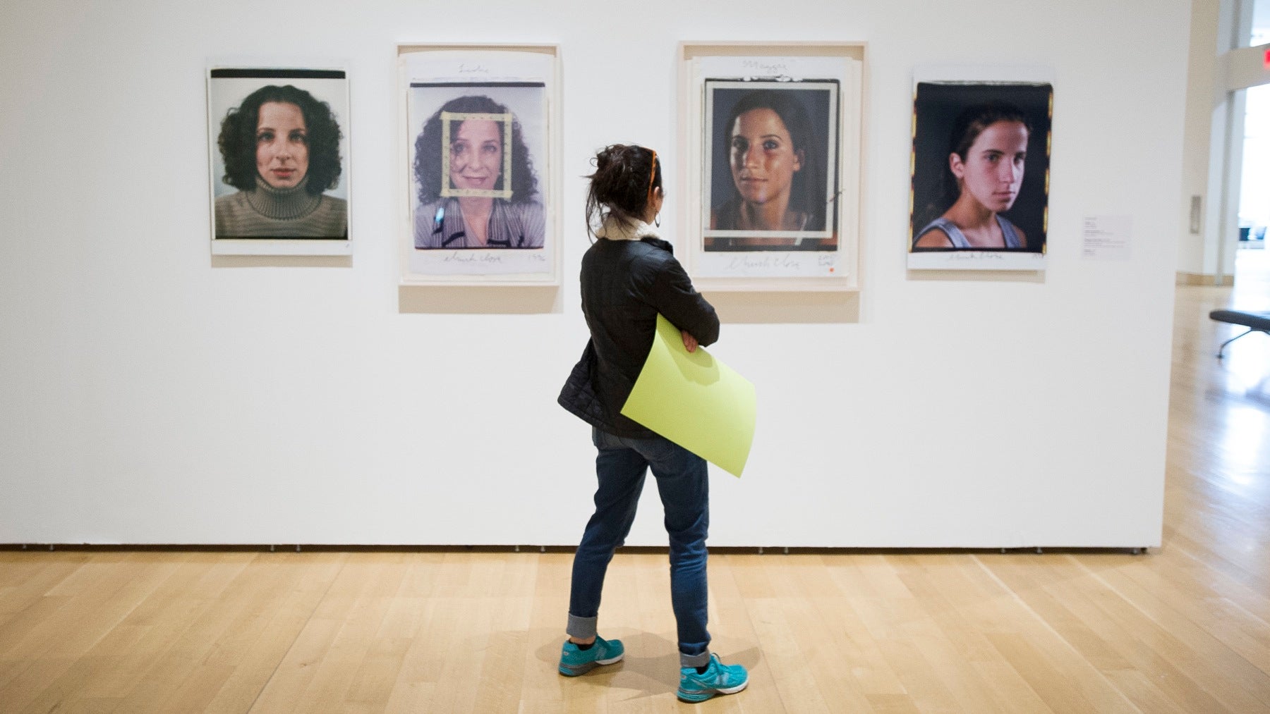 Tamara Weiss carries her protest poster with her as she views the Chuck Close exhibit. 