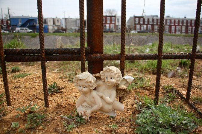 Cleaners leave one piece of trash behind while cleaning up a site near a former heroin encampment on Gurney Street in Philadelphia's Fairhill neighborhood. (Emma Lee/WHYY)