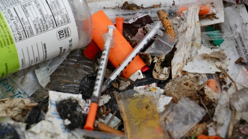 Hundreds of syringes were found during the cleanup of the block-long stretch of grass between Gurney Street and the Conrail tracks. (Emma Lee/WHYY)