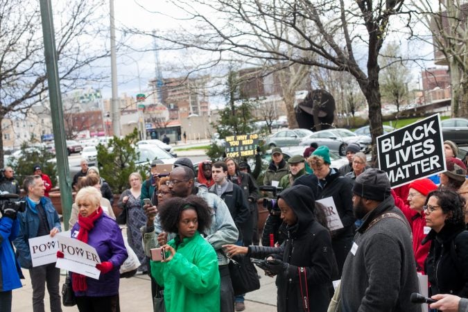 Demonstrators gather in front of the Philadelphia Police Department Headquarters Thursday before marching up Market Street in response to an incident where two black men who were arrested in a Center City Starbucks last week. (Brad Larrison for WHYY)