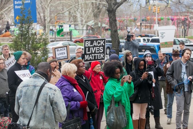 Demonstrators gather in front of the Philadelphia Police Department Headquarters Thursday before marching up Market Street in response to an incident where two black men who were arrested in a Center City Starbucks last week. (Brad Larrison for WHYY)