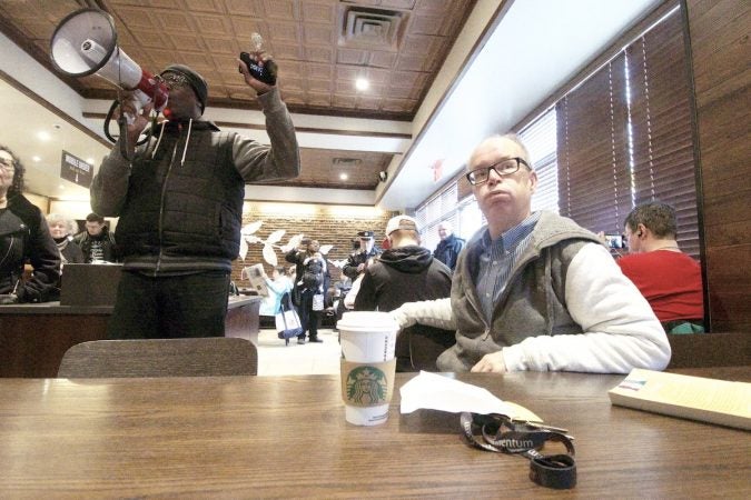 People gather inside a Starbucks on 18th and Spruce streets in Philadelphia to protest Thursday's controversial arrest. (Bastiaan Slabbers for WHYY)