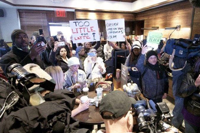 People gather at a Starbucks on 18th and Spruce streets in Philadelphia to protest Thursday's controversial arrests of two black men at the store. (Bastiaan Slabbers/for WHYY)