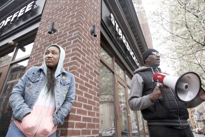 People gather outside a Starbucks on 18th and Spruce streets in Philadelphia to protest Thursday's controversial arrests of two black men at the store. (Bastiaan Slabbers/for WHYY)