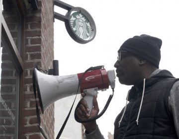 Asa Khalif of Black Lives Matter uses a bullhorn during an April protest at Starbucks in Center City Philadelphia. (Bastiaan Slabbers/for WHYY)