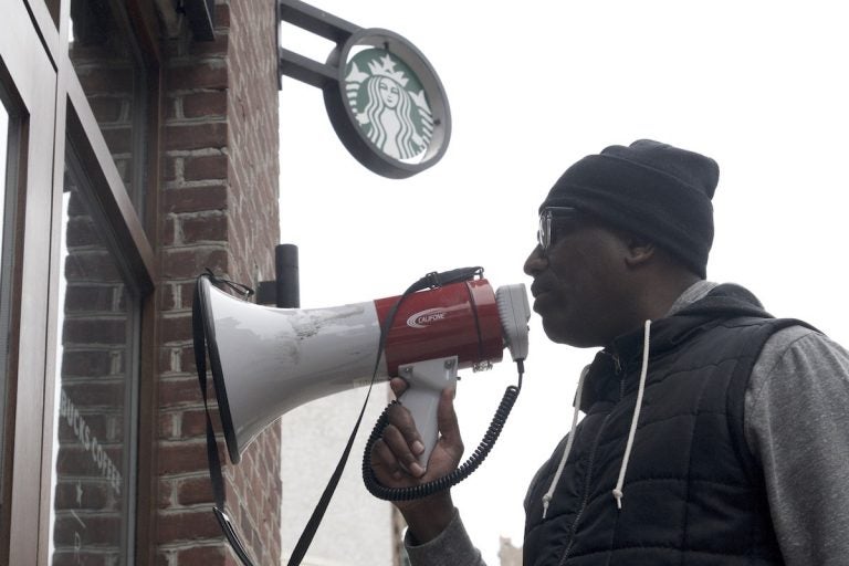 Asa Khalif of Black Lives Matter uses a bullhorn during an April protest at Starbucks in Center City Philadelphia. (Bastiaan Slabbers/for WHYY)