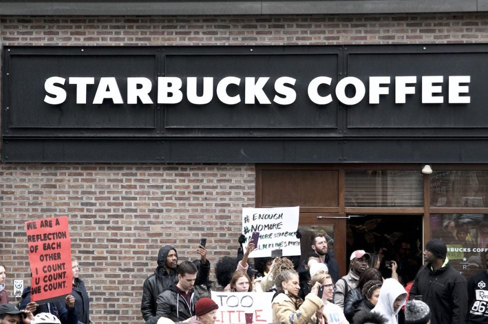 People gather outside a Starbucks on 18th and Spruce streets in Philadelphia to protest Thursday's controversial arrests of two black men at the store. (Bastiaan Slabbers/for WHYY)