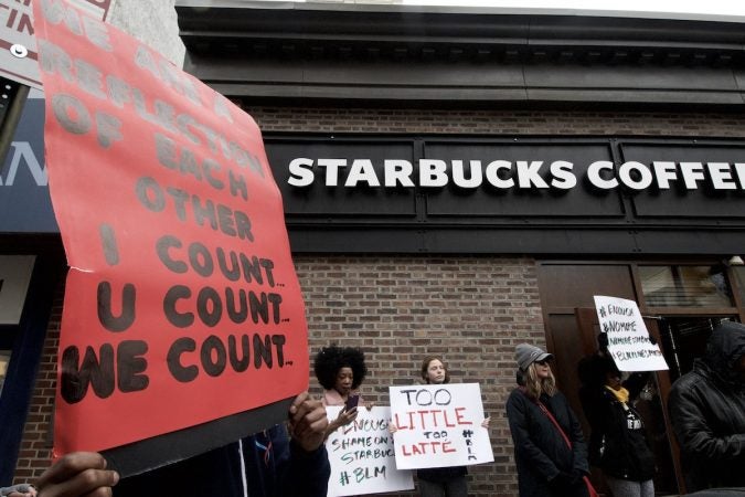 People gather outside a Starbucks on 18th and Spruce streets in Philadelphia to protest Thursday's controversial arrests of two black men at the store. (Bastiaan Slabbers/for WHYY)