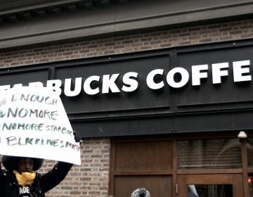 People gather outside a Starbucks on 18th and Spruce streets in Philadelphia to protest Thursday's controversial arrests of two black men at the store. (Bastiaan Slabbers/for WHYY)