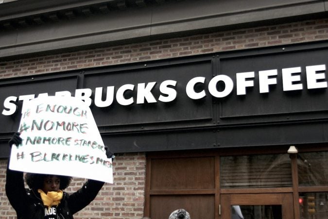 People gather outside a Starbucks on 18th and Spruce streets in Philadelphia to protest Thursday's controversial arrests of two black men at the store. (Bastiaan Slabbers/for WHYY)