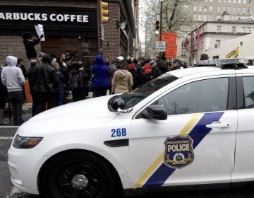 People gather outside a Starbucks on 18th and Spruce streets in Philadelphia to protest Thursday's controversial arrests of two black men at the store. (Bastiaan Slabbers/for WHYY)