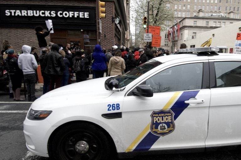 People gather outside a Starbucks on 18th and Spruce streets in Philadelphia to protest Thursday's controversial arrests of two black men at the store. (Bastiaan Slabbers/for WHYY)