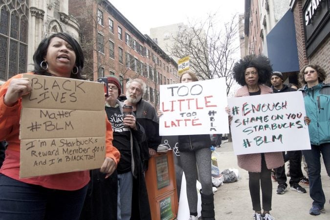 People gather outside a Starbucks on 18th and Spruce streets in Philadelphia to protest Thursday's controversial arrests of two black men at the store. (Bastiaan Slabbers/for WHYY)