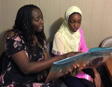 Aminata Sy reading to Dieynaba, an eighth-grader from Senegal who recently came to the U.S. (Photo courtesy of Aminata Sy)