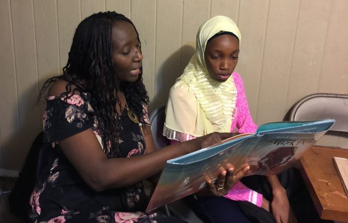 Aminata Sy reading to Dieynaba, an eighth-grader from Senegal who recently came to the U.S. (Photo courtesy of Aminata Sy)