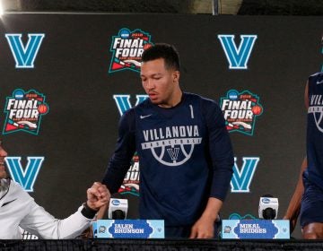 Villanova head coach Jay Wright, left, offers to bump his fist as Jalen Brunson and Mikal Bridges arrive at a news conference for the championship game of the Final Four NCAA college basketball tournament, Sunday, April 1, 2018, in San Antonio. (AP Photo/Brynn Anderson)