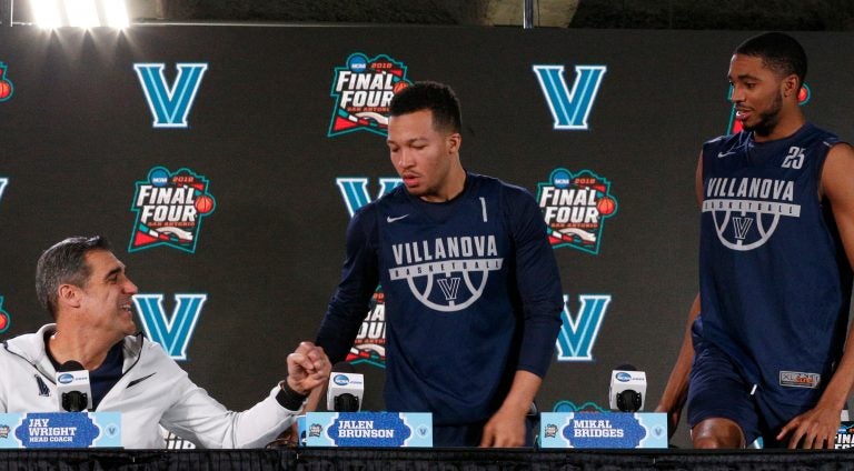 Villanova head coach Jay Wright, left, offers to bump his fist as Jalen Brunson and Mikal Bridges arrive at a news conference for the championship game of the Final Four NCAA college basketball tournament, Sunday, April 1, 2018, in San Antonio. (AP Photo/Brynn Anderson)