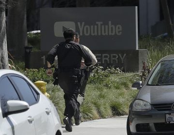 Officers run toward a YouTube office in San Bruno, Calif., Tuesday, April 3, 2018. Police say they’re responding to an active shooter at YouTube headquarters.
