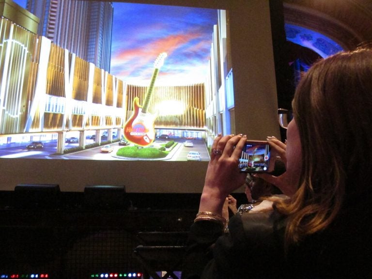 This April 18, 2018 photo shows a media member taking photos of a video presentation about the new Hard Rock casino during a press conference in New York at which the company announced its Atlantic City casino will open on June 28. (Wayne Parry/AP Photo)