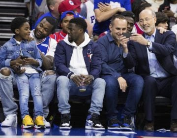 Rapper Meek Mill, (center left), looks on with his son, (left), and actor Kevin Hart, (center), as 76ers' co-owner Michael Rubin, (center right), looks at Pennsylvania Gov. Tom Wolf's phone, (right), during the first half in Game 5 of a first-round NBA basketball playoff series between the Miami Heat and the Philadelphia 76ers, Tuesday, April 24, 2018, in Philadelphia. The 76ers won 104-91. (Chris Szagola/AP Photo)